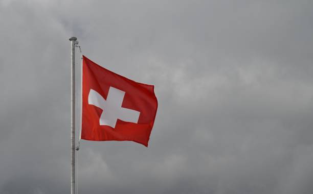 istock Swiss flag on cloudy sky, waving proudly 2155886987
