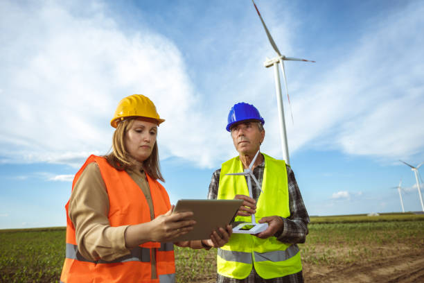 istock Two engineers working and looking at the report wind turbine farm. 2155887881