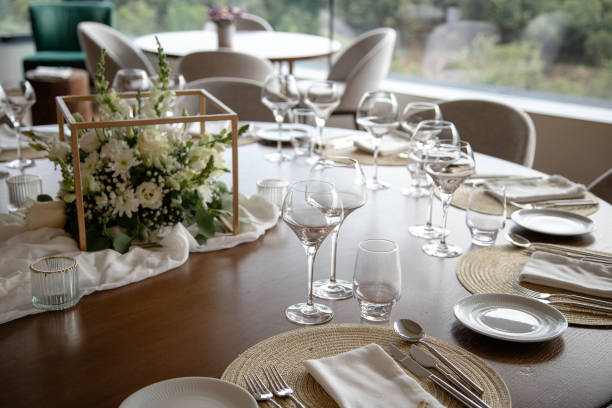 istock Elegant dining table set for a special event, featuring a beautiful floral centerpiece, wine glasses, and finely arranged utensils, creating a sophisticated and welcoming atmosphere. 2155889535