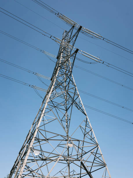istock Electricity pylon and power lines seen from below against blue sky 2155891066