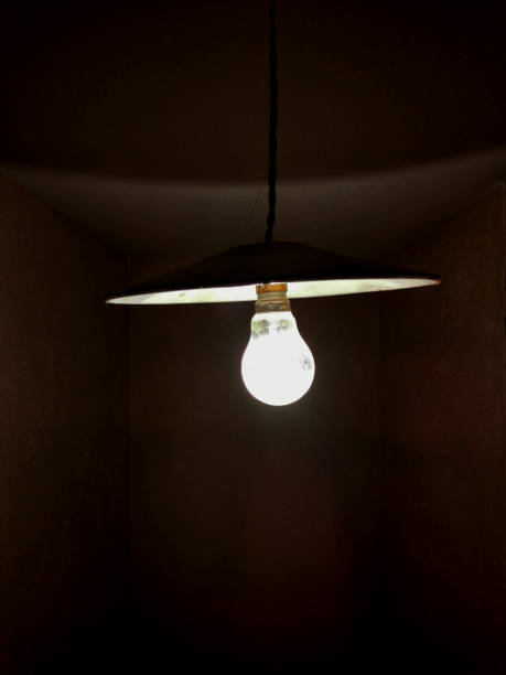 istock Light bulb glowing in a dark room. 2155891127