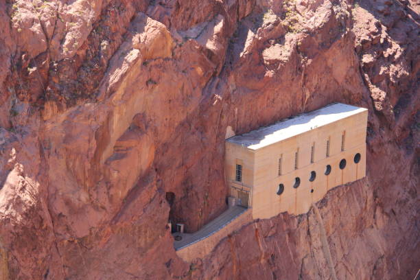 A building constructed within a rock formation by a mountainside. Hoover Dam, USA
