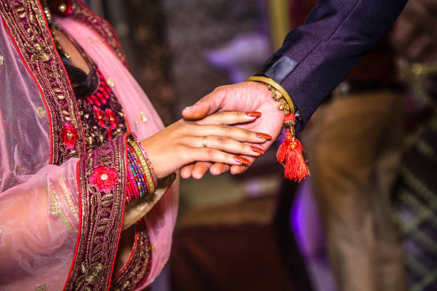 istock Couple in traditional attire clasps hands 2155895690