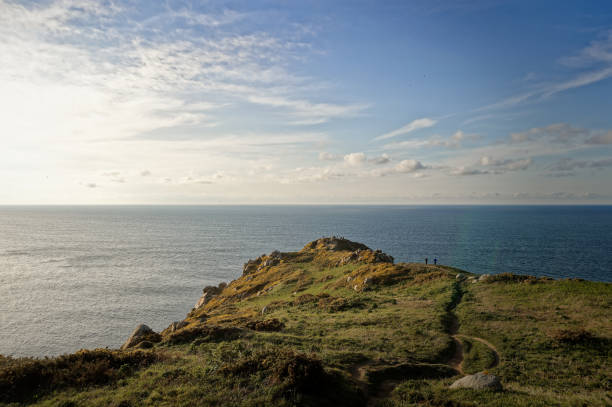 istock People standing on a mountain peak overlooking the ocean 2155895922
