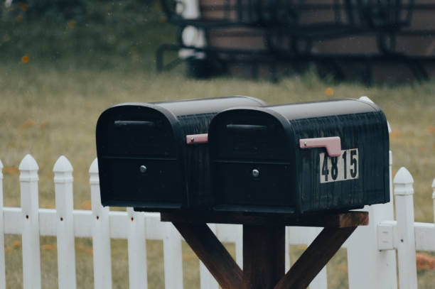 istock Close-up of mailboxes on a post in front of a white fence 2155896237