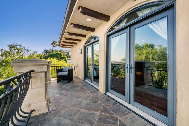 istock balcony with view to trees, stone patio and chair with black iron railing 2155900612