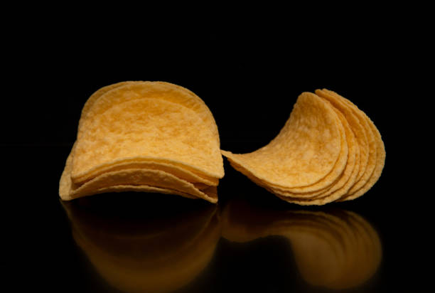 istock Close-up with a group (pile) of potato chips on a black background. 2155900703