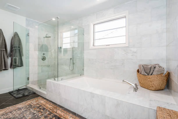 istock a bathtub sitting next to a bathroom filled with white marble tiles 2155900803