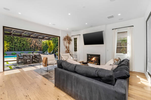 istock living room with fireplace, television and glass doors overlooking backyard 2155901007