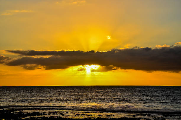 istock The sun is setting over the ocean, casting a warm glow on the water 2155901383