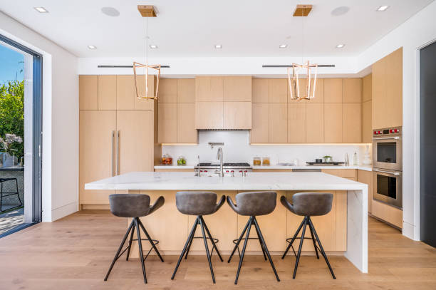 istock large white kitchen with marble island, wooden cabinetry and bar stools 2155901438