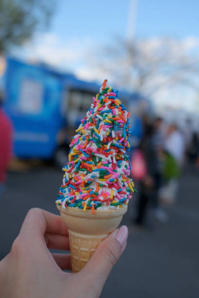 istock Hand holding ice cream cone with sprinkles 2155902434