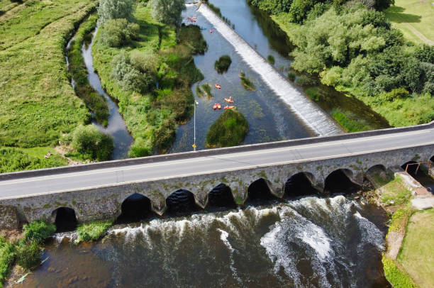 An aerial view of a bridge over a river, surrounded by trees