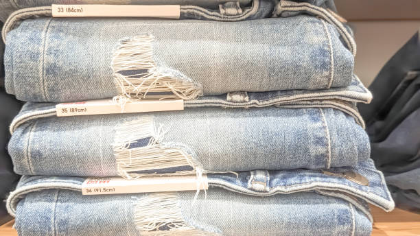 istock Close-up view. A stack of torn denim jeans on the rack 2155903078