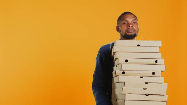 istock Clumsy deliveryman dropping a huge stack of pizza boxes in studio 2155903911