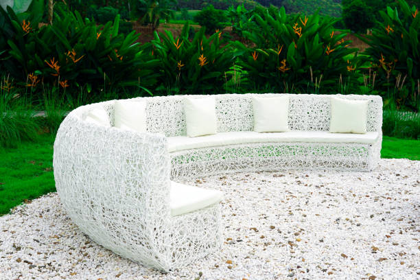 White field sofa, artificial rattan sofa Used architecture to sit and relax outdoors and admire the natural scenery and the surrounding trees. Soft and selective focus.