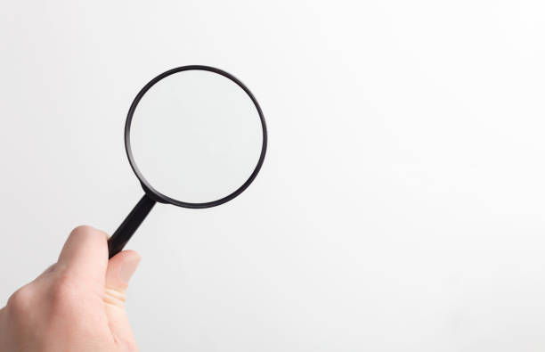 istock lens, black magnifying glass in hand in hand on a white background 2155909654