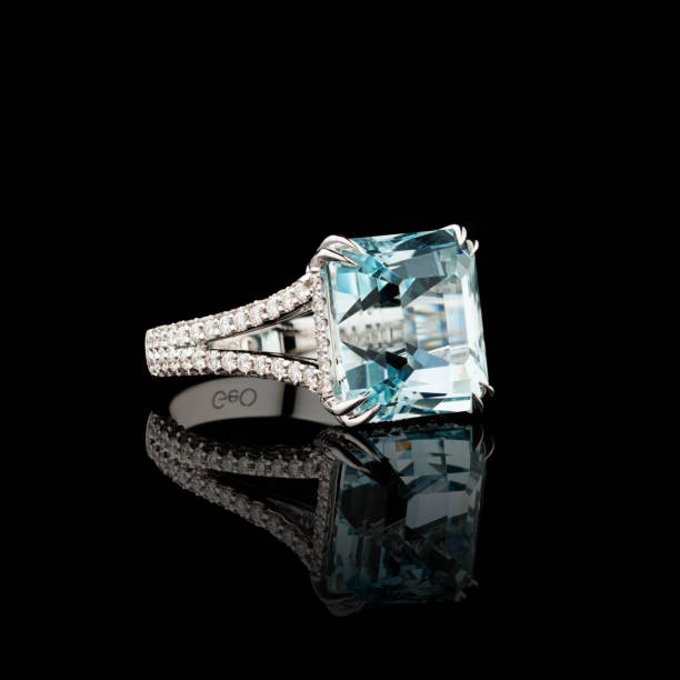 istock Beautiful white gold ring with diamonds and aquamarine on a black background 2155909903