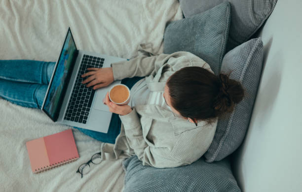 istock Woman in bed using lap top and drinking coffee 2155911630