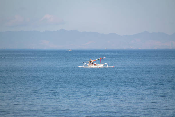 A woman is walking on beach after swimming.Sanur beach - Bali Island - Indonesia.