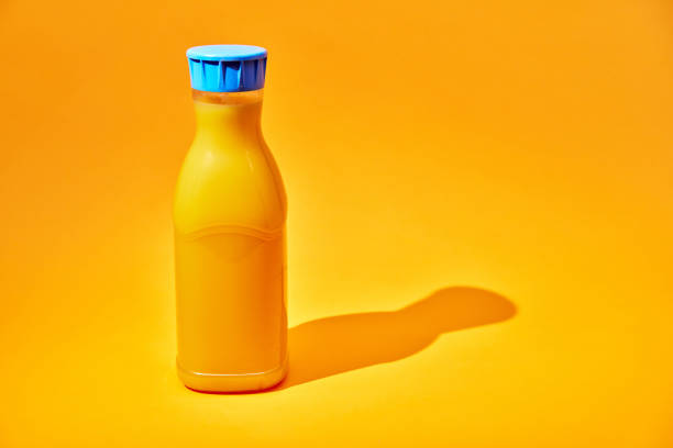 Orange Juice in Recycled PET Plastic Bottle on Yellow Background
