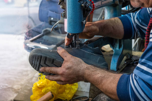 istock A cobbler is repairing an old shoe. 2155920711