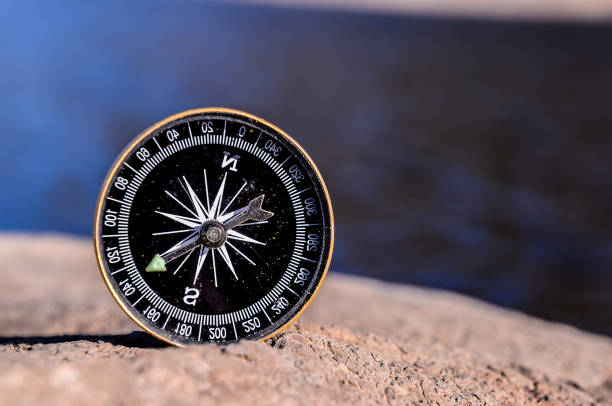 istock A compass is sitting on a rock by a body of water 2155920867