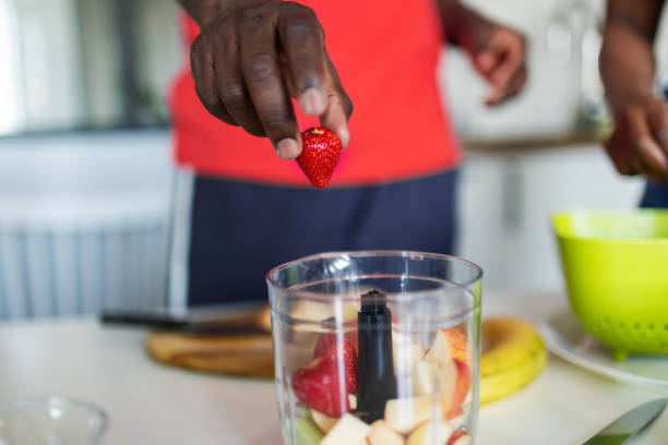 istock Closeup on hand with strawberry above blender 2155922645