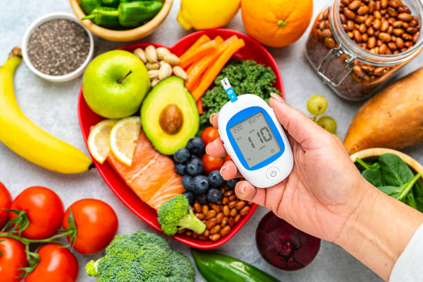 istock Hand holding glucometer on healthy food background 2155925111