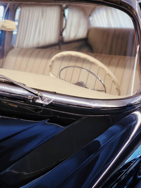 istock Black retro car windscreen with beige leather interior and steering wheel. 2155926696
