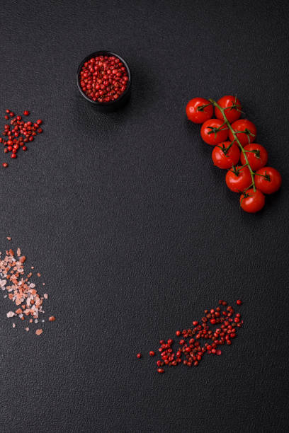 istock Black background with copy space with cherry tomatoes, salt, spices 2155927898