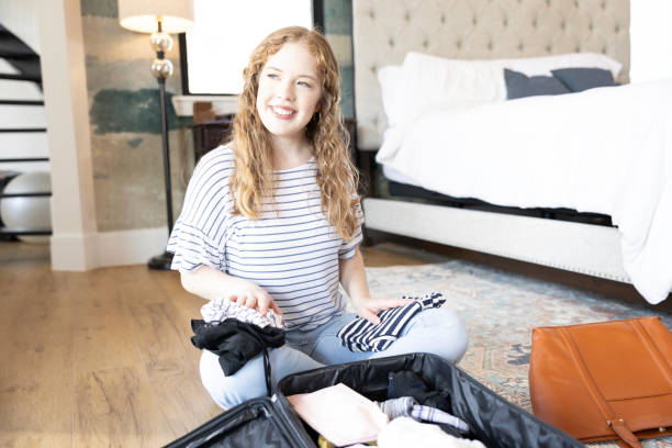 istock Packing suitcase, woman daydreams about trip 2155928020