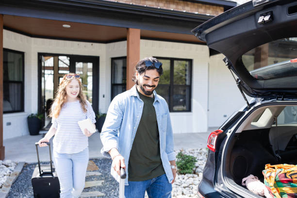 istock Leaving bed and breakfast, young man prepares to load suitcase in car 2155928071