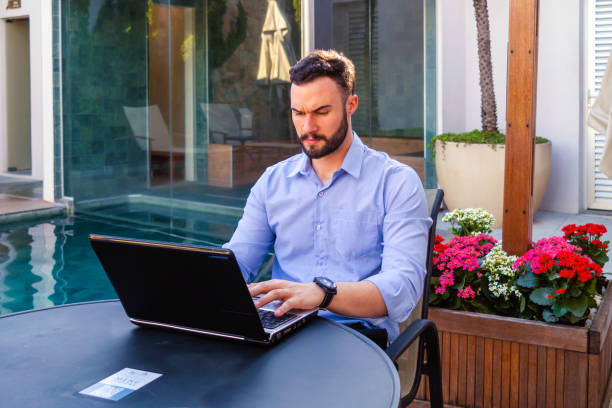 istock Businessman working with a laptop in a hotel lobby 2155928488