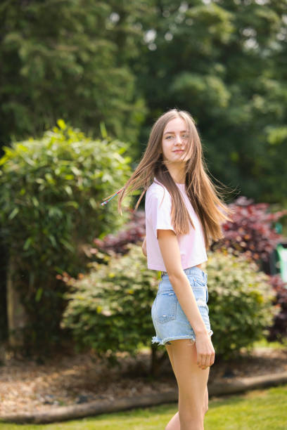 Hazel-eyed teenager wearing denim shorts and a crop top.