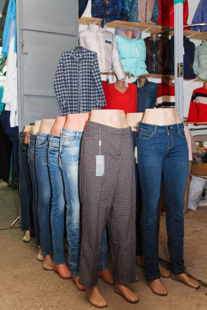 Clothing warehouse. Various trousers, pants and jeans dressed on mannequins are displayed in a row