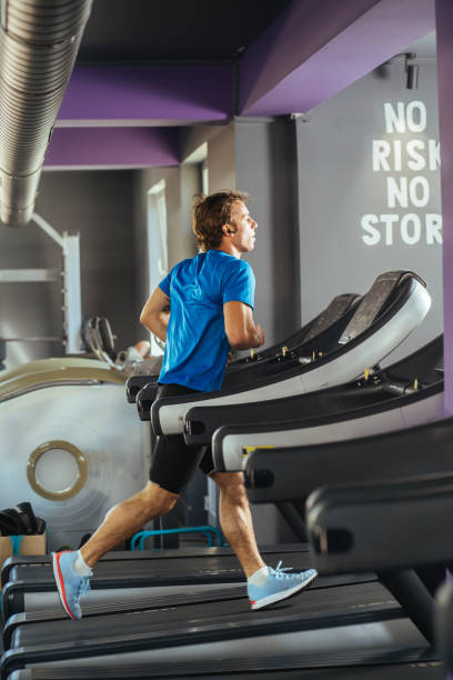istock Young man doing cardio excercise at the gym , running on a treadmill 2155937165