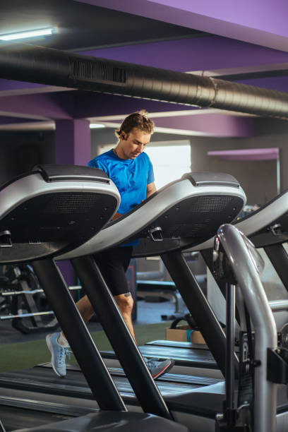 istock Young man doing cardio excercise at the gym , running on a treadmill 2155937201