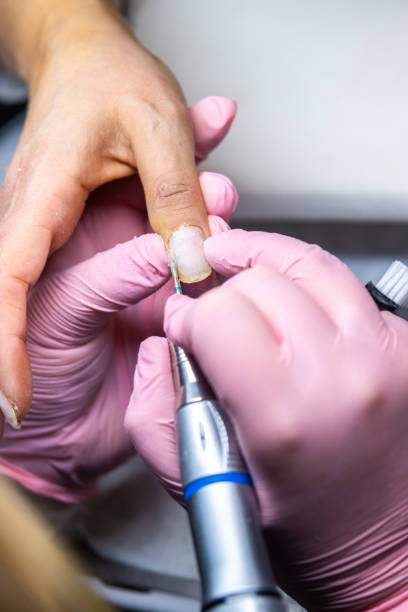 istock Manicurist using electric file for nail care in salon 2155938816
