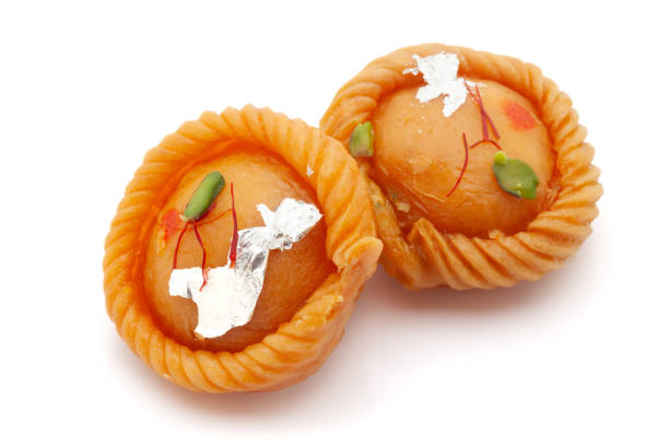 dos piezas de dulce tradicional indio "chandrakala", rellenas de frutos secos. vista frontal. aislado sobre un fondo blanco. - gujia fotografías e imágenes de stock