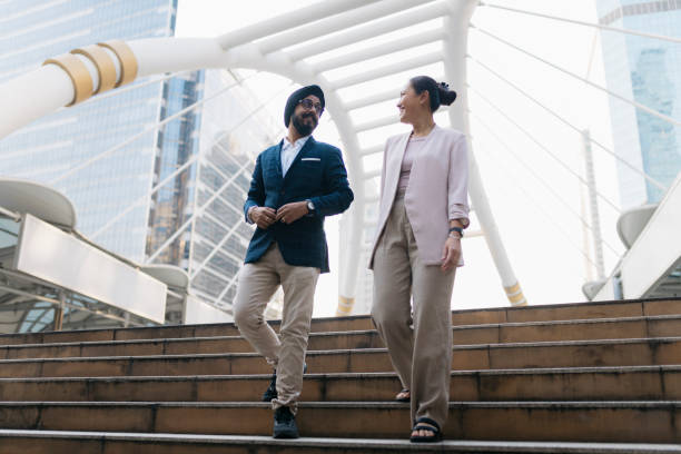 istock Two businesspeople talking while walking down the steps together the city 2155942059