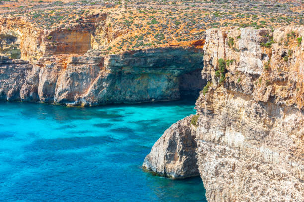 Comino island in Malta features turquoise waters and rocky coastal formations