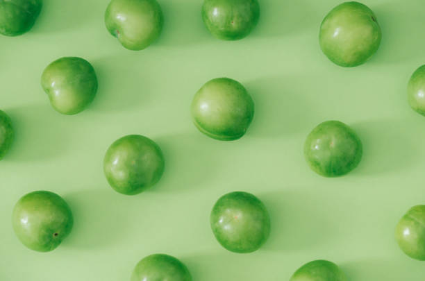 istock Trendy fruit pattern made of fresh green plums on light pastel green background. Minimal layout. Nature summer concept. 2155945596