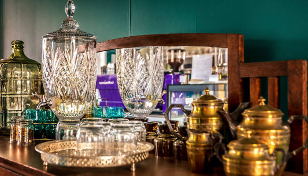 Antique glassware and brass serving ware on an antique side table