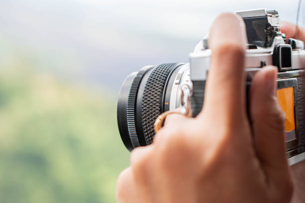 istock Woman photographing with vintage camera 2155946698