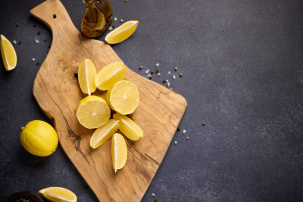 Sliced lemon fruit on a wooden cutting board at domestic kitchen.