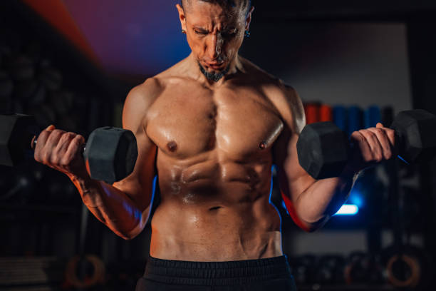 istock Man covered in sweat training in style gym with heavy dumbbells 2155948077