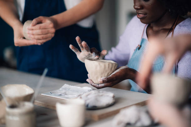 istock Close up of diverse attendee's hands shaping clay at pottery studio. 2155948087