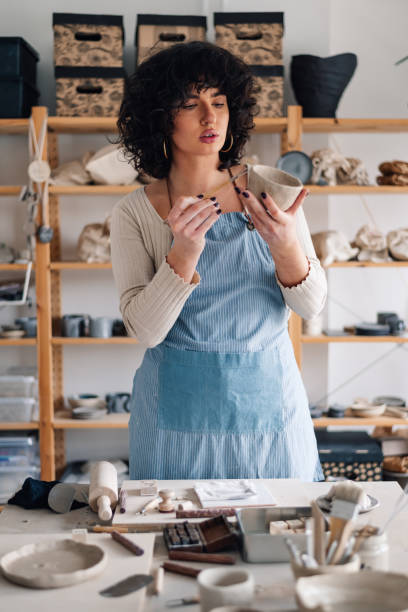istock Portrait of creative pottery designer decorating clay work at atelier. 2155948098