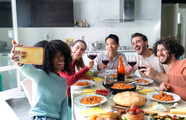 Group Of Friends Taking Selfies During Lunch indoors